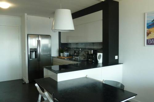 邦多勒Front de mer - Emplacement prisé - T2 moderne et climatisé - Tout à pied的厨房配有黑色台面和冰箱