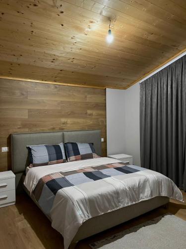 都拉斯Albanian Traditions Legacy的一间卧室设有一张带木制天花板的大床