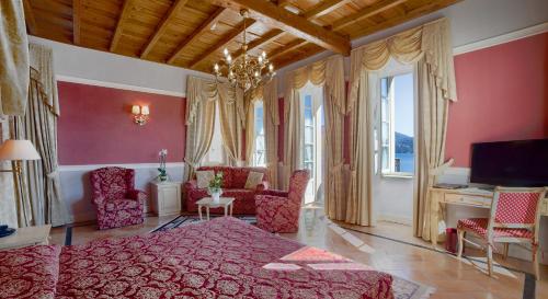 卡尼洛瑞维拉Hotel Cannero的卧室设有粉红色的墙壁和一张床及椅子