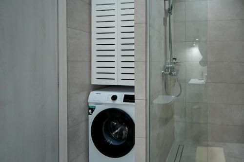 马斯蒂查里Aegean Sunset Villas的带淋浴的浴室内的洗衣机