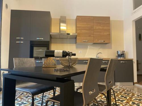 玛格丽塔萨沃亚Maioliche Apartments的厨房配有黑色的桌子和椅子