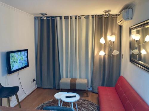 圣地亚哥阿莫布拉达斯蒙马特普罗维登公寓的客厅配有红色沙发和电视