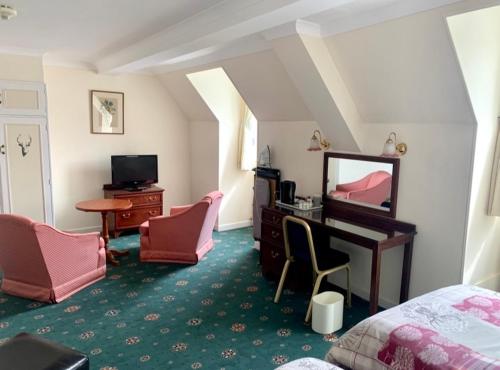洛哈尔什教区凯尔高地Lochalsh Hotel with Views to the beautiful Isle of Skye的一间卧室配有一张床和一张带镜子的书桌