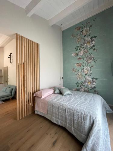 Montefiore ConcaAgriturismo La Pedrosa的卧室配有一张带花卉壁画的床。