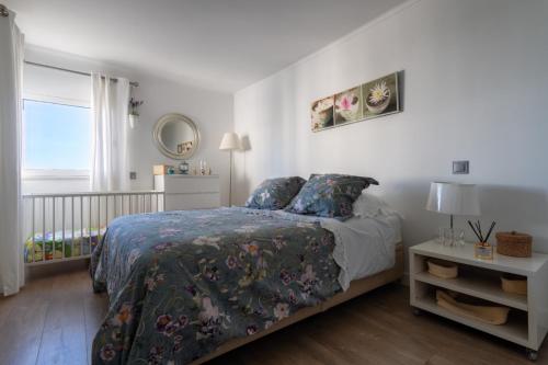 奎特里拉Apartamento Deluxe AM的一间卧室配有一张带花卉床罩的床和窗户。