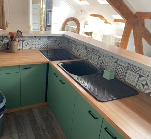 CourcyCocon的厨房配有绿色橱柜和水槽