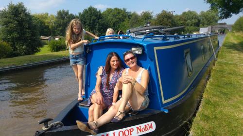 奥尔德马斯顿Narrowboat canal holiday from19th august的三个女孩坐在蓝色小船的后面