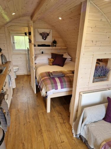 ScourieTighlochan pods的小木屋内一间卧室,配有两张床