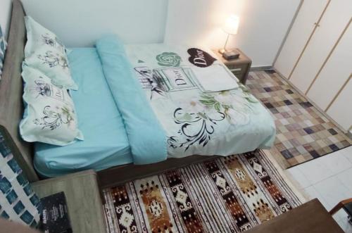 阿布扎比SMD Comfy Apartments的一张带蓝色床单和枕头的床