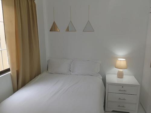 瓜亚基尔Comfortable 3-Bedroom Condo in Bellavista, Guayaquil的一间小卧室,配有白色的床和一盏灯