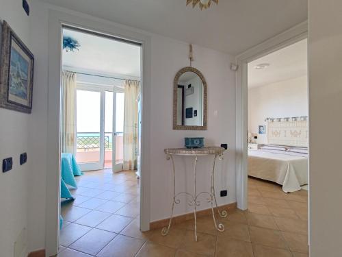 内比达Splendida vista sul mare的走廊上设有一间卧室,配有一张床和镜子