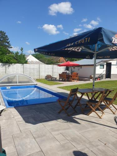 博尔多格克瓦劳尔尧Wellness Villa Diana的一个带桌子和遮阳伞的游泳池