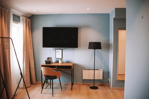 勒丁恩Lødingen Brygge的客房设有书桌和墙上的电视。