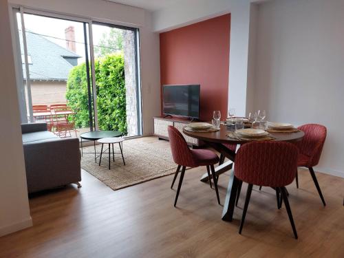罗德兹La Villa Bompard*** 50m² Cœur de ville avec terrasse的一间带桌椅和电视的用餐室