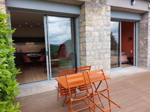 罗德兹La Villa Bompard*** 50m² Cœur de ville avec terrasse的木制甲板上的木桌和椅子