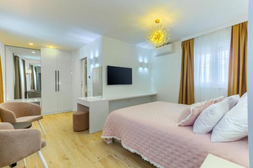 斯普利特Irini Luxury Rooms的一间白色卧室,配有床和电视