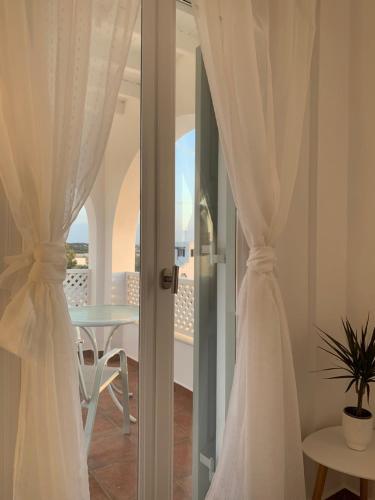 纳克索斯岛卡斯特拉基Sea and Salt Naxos 3的客房设有白色窗帘、桌子和阳台