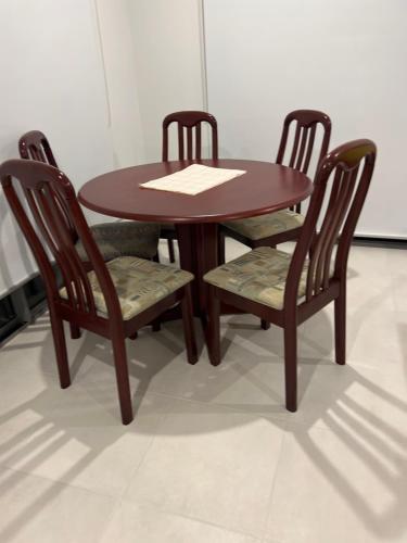克兰伯恩Ann pavilion Paradise的一张木桌,配有两把椅子和一张桌子,上面有纸张