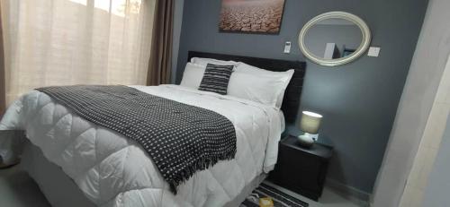 KitweZachi Apartments的一间卧室配有一张大床和镜子