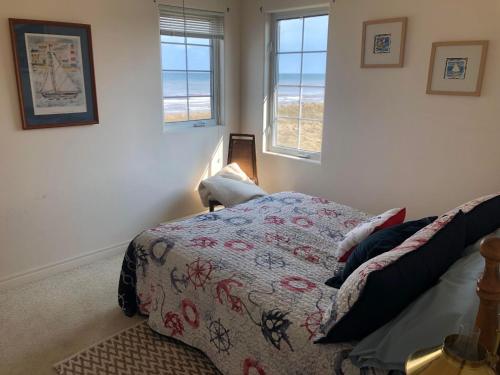 TracadiePhare des Dunes Lighthouse的一间卧室设有一张床和两个窗户。