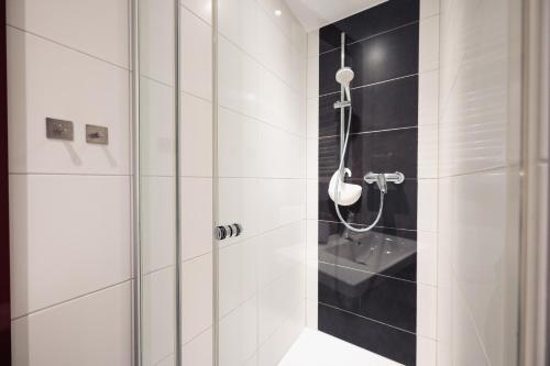 明斯特Hotel Busche am Dom的浴室铺有黑白瓷砖,设有淋浴。