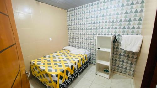 马瑙斯Apartamento 3 Aconchegante São Jorge的一间小卧室,配有黄色和黑色的床