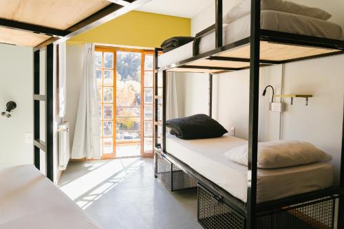 圣马丁德洛斯Bike Hostel的客房设有两张双层床和一扇窗户。