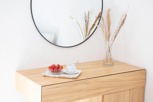 奈德里Adria Luxury Apartments的木梳妆台上方的镜子,上面有一碗水果