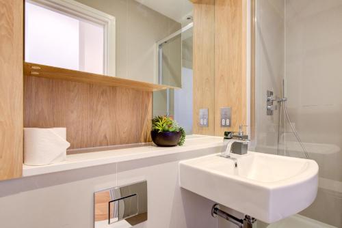 卢顿The Landmark, Lutons best location的白色的浴室设有水槽和镜子