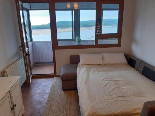 莫格罗Santander Mogro的一间卧室配有一张床、一张沙发和窗户。