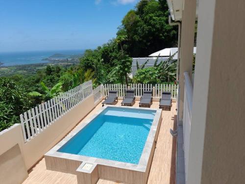 勒沃克兰Villa Sirius vue sur mer的游泳池位于阳台,周围设有椅子