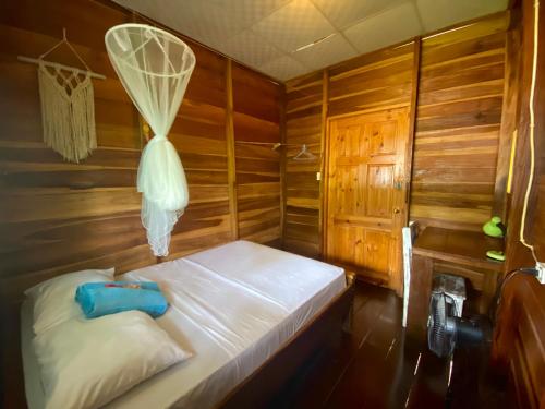 巴斯蒂门多斯True Nature Jungle House的木制客房内的一间卧室,配有一张床