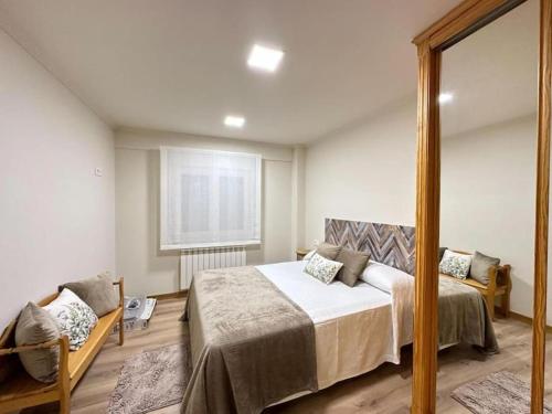 维戈Amplio apartamento con terraza en Bouzas, cerca de la playa.的一间卧室配有一张大床和镜子