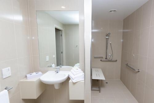 墨尔本墨尔本亚特兰蒂斯酒店 的白色的浴室设有水槽和淋浴。