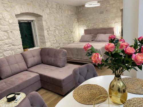 斯拉汀Garma的客厅配有一张床、一张沙发和玫瑰花