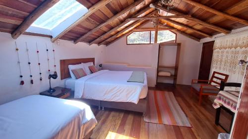 奥兰太坦波Luisa的一间铺有木地板的客房内配有两张床的卧室