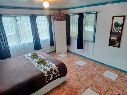 AmuriAitutaki Budget Accommodation的一间设有床铺的卧室,位于带窗户的房间内