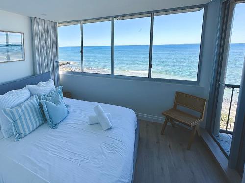 卡伦德拉Monterey Lodge - Unit 18, 27 Warne Terrace, Kings Beach Caloundra的一间卧室设有一张床,享有海景