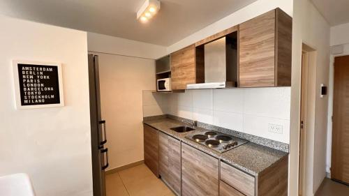 莫龙machado apartamentos moron的厨房配有木制橱柜和台面