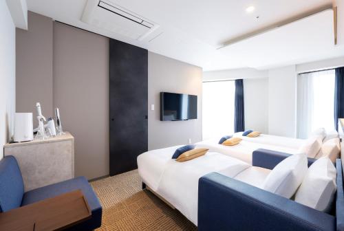 东京HOTEL AMANEK Shinjuku Kabukicho的一间酒店客房,设有两张床和电视