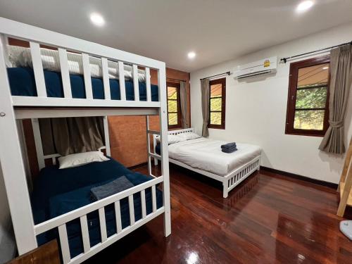Ban Pracham Mai BonD.I.N @ทองผาภูมิ的一间卧室配有两张双层床。