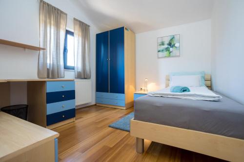 奥米沙利APARTMANI BEBA的一间卧室配有一张床和一个蓝色的橱柜