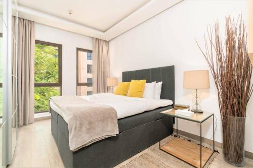 迪拜Stunning Apt with Spacious Terrace Old Town Dubai的一间卧室配有一张带黑色床头板和一张桌子的床。