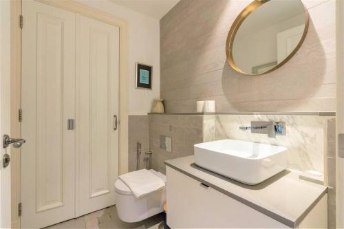 迪拜Stunning Apt with Spacious Terrace Old Town Dubai的一间带水槽、镜子和卫生间的浴室