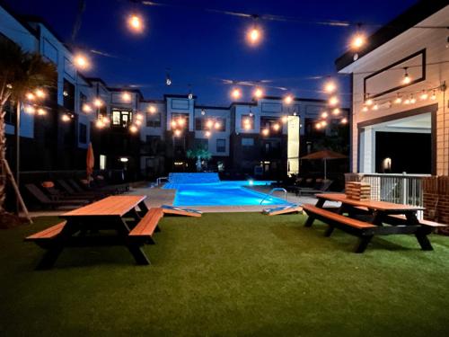 休斯顿Comfy Abode near Bush Airport的一个带长椅的庭院和一个夜间游泳池