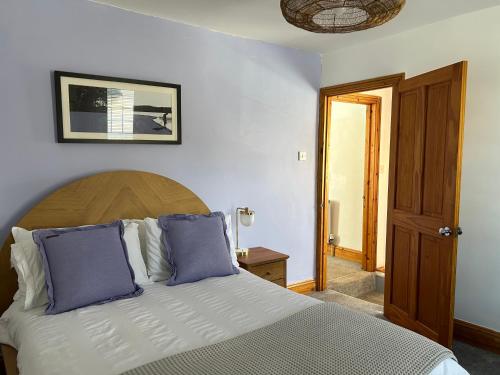 廷茅斯Fully Equipped Devon 2BR Cottage的一间卧室配有一张带蓝色枕头的大床