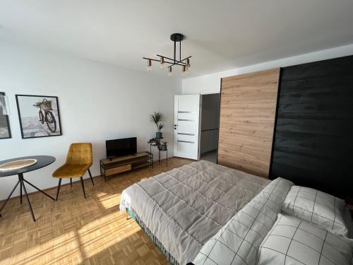 克卢日-纳波卡C & A apartments的卧室配有1张床、1张桌子和1把椅子