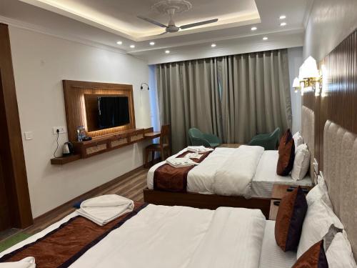 列城Hotel Youthok Heritage的酒店客房设有两张床和电视。