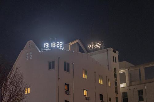 清州市Aank Hotel Cheongju 1的一座建筑,上面有夜钟