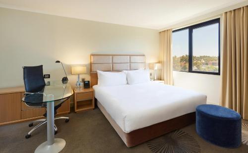 悉尼帕拉马塔假日酒店的配有一张床、一张书桌和一扇窗户的酒店客房